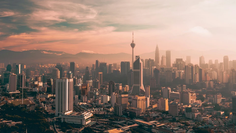 Kuala Lumpur Tower, the Petronas Twin Towers, and the city skyline at sunset