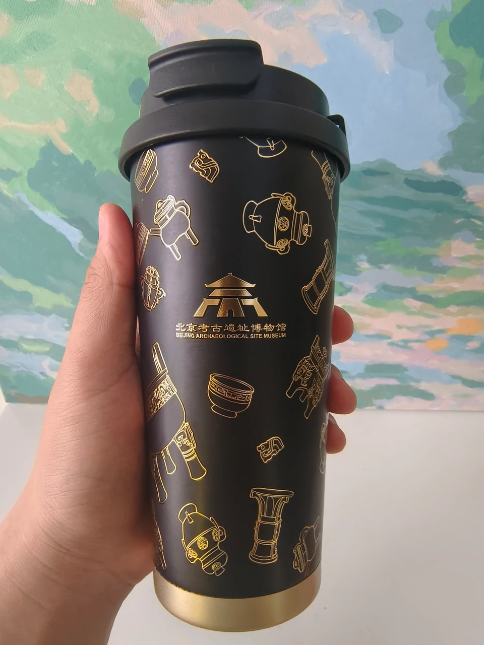 Coffee mug printed with the museum's name and artifact motifs