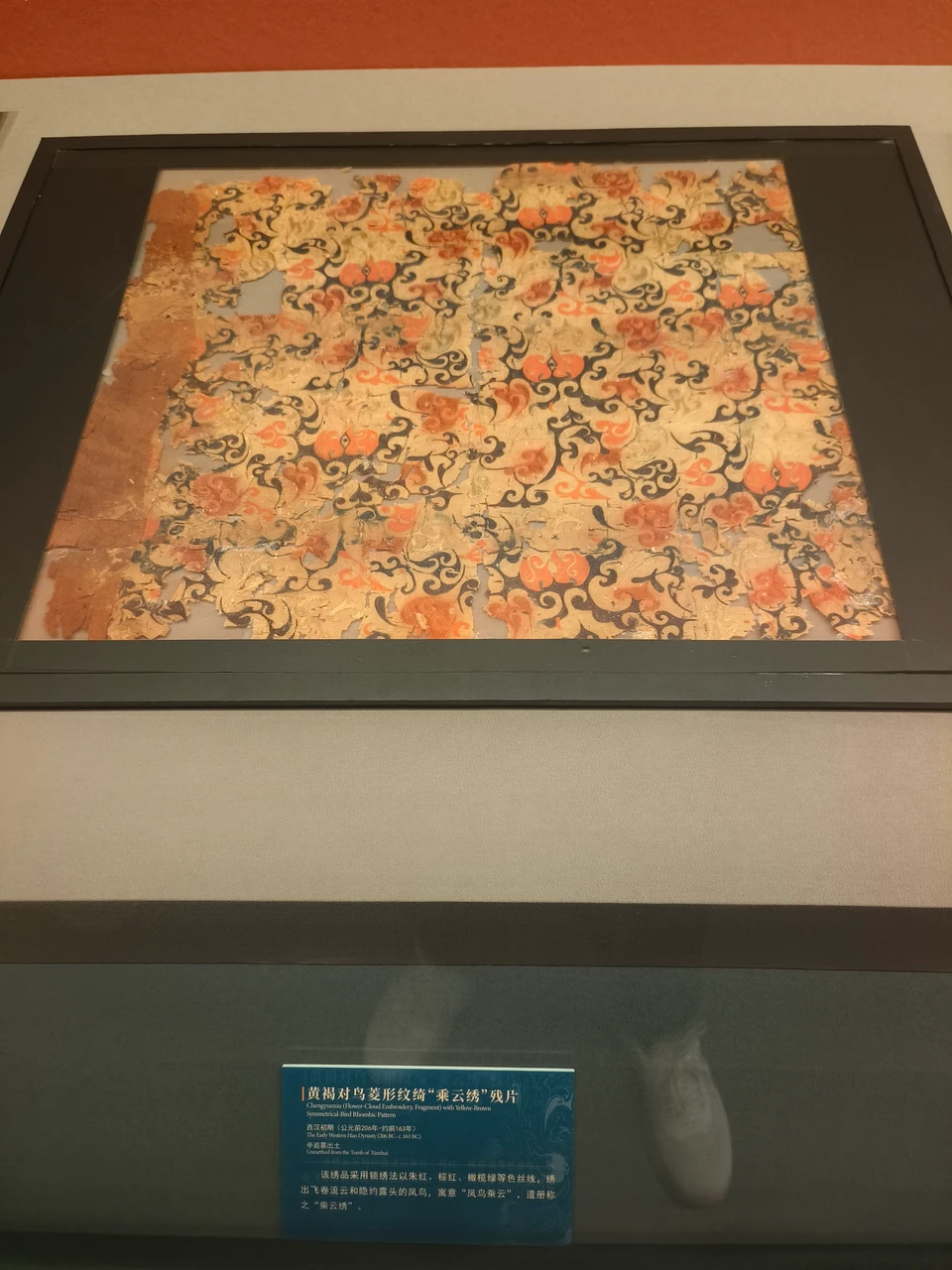 Silk textile with a scrolling-plant pattern and its label