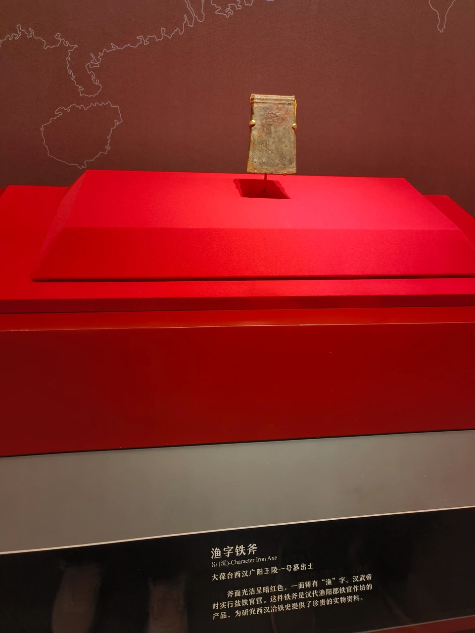 The Yu-marked iron axe, its display stand, and artifact label