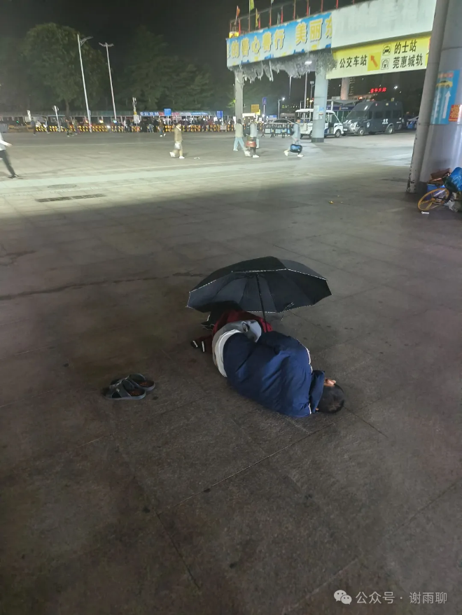 车站广场上撑伞休息的人